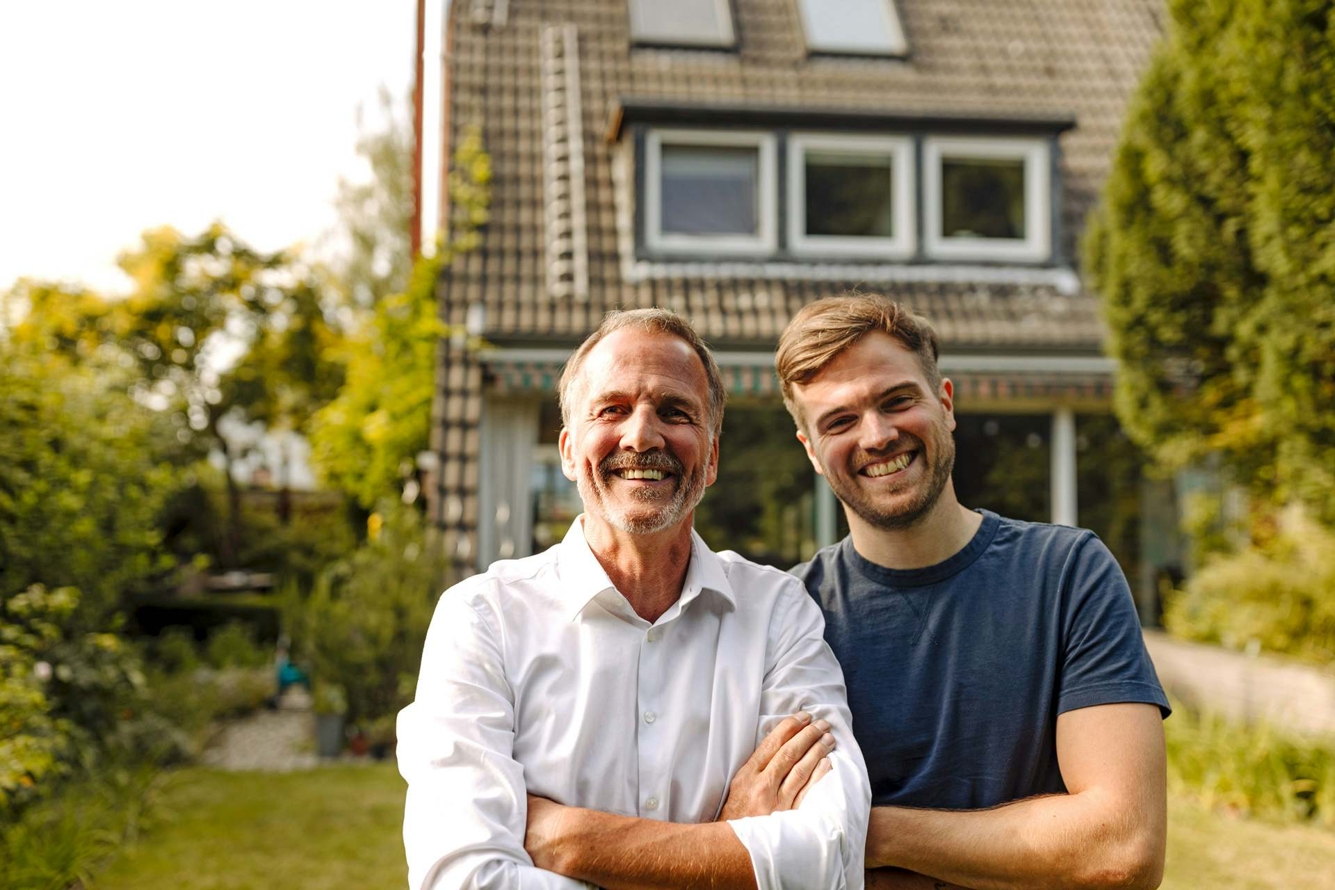 Padre e hijo sonriendo después de instalar paneles solares en su casa