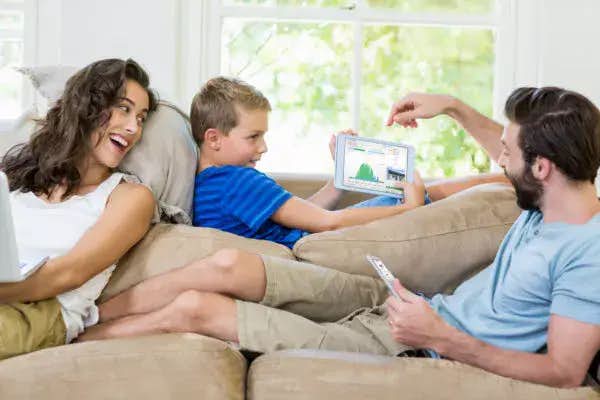 happy family in the living room holding a gadget
