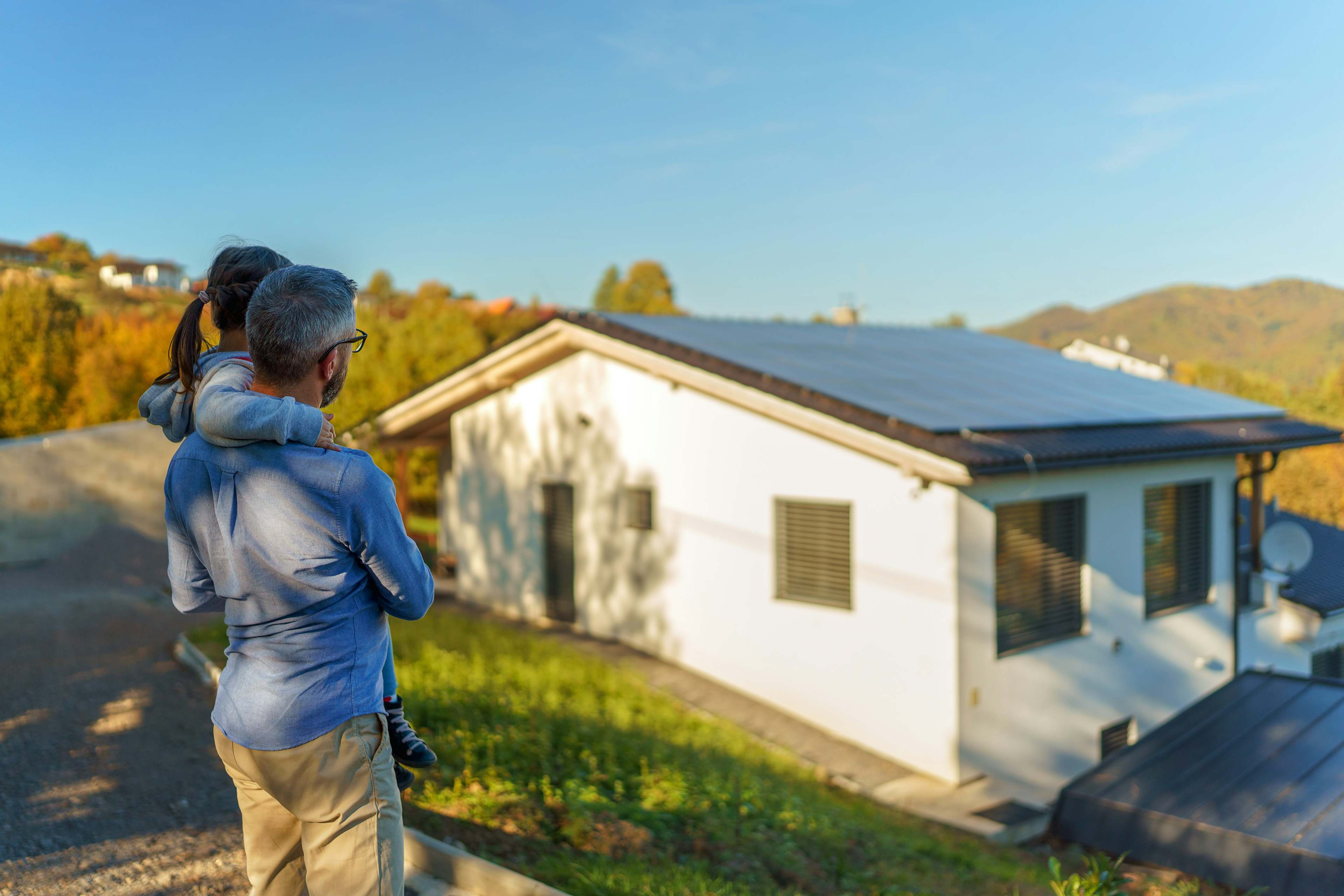 dad with little girl looking at home with solar