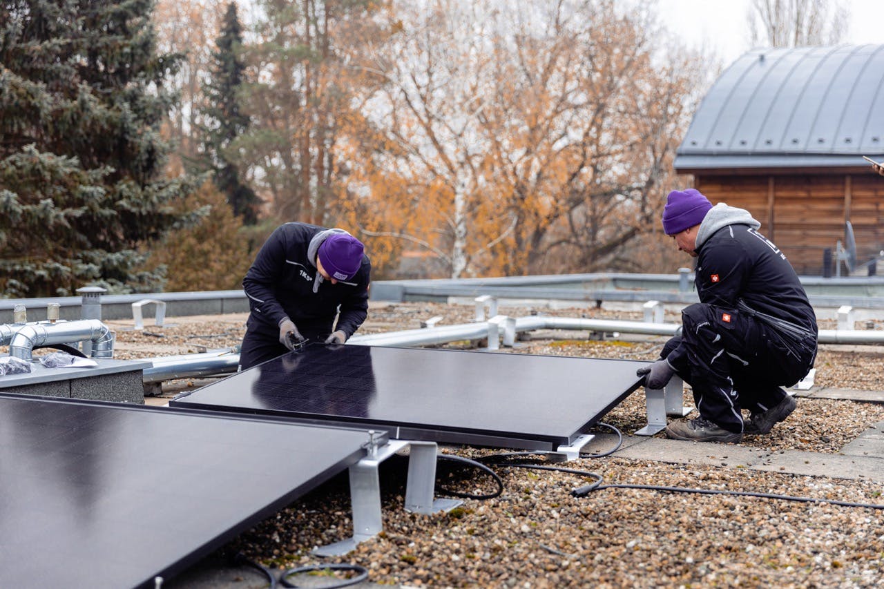 Handwerker bei der Solaranlagen Installation auf einem Flachdach