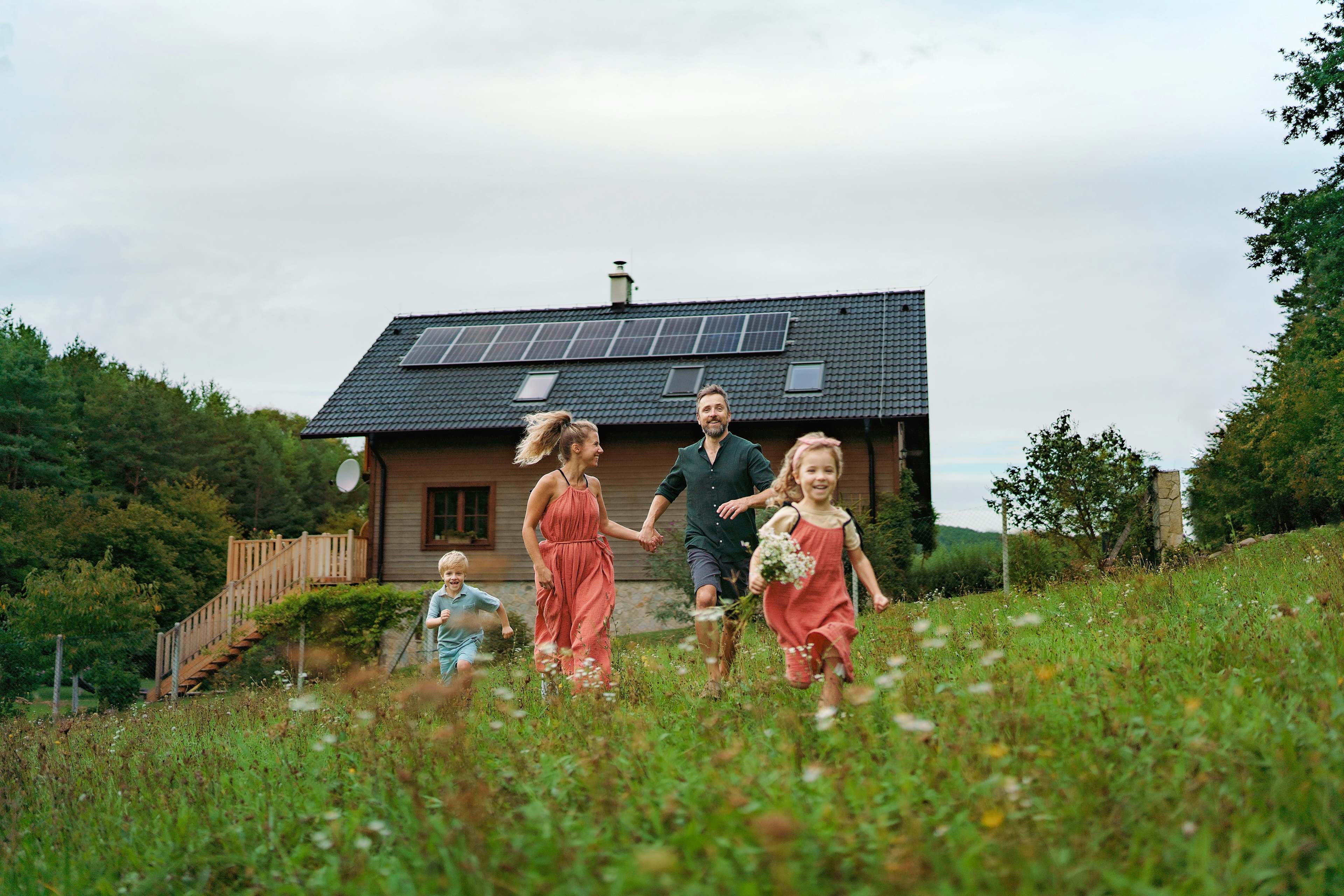 happy family running near their house with solar